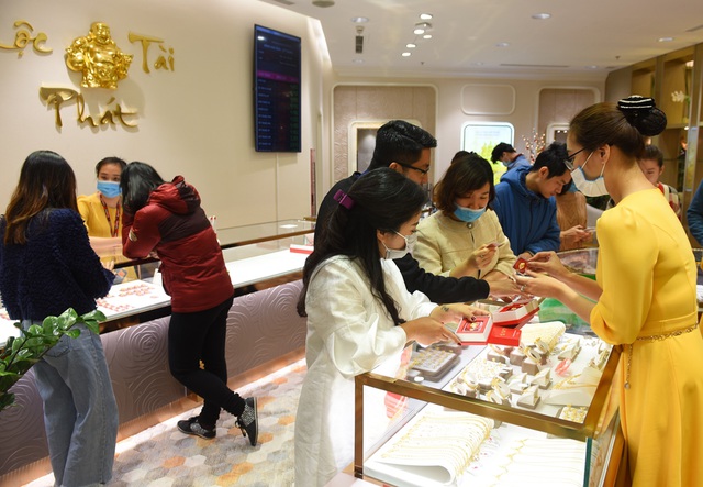 Nhân viên bán hàng đeo khẩu trang tư vấn cho khách