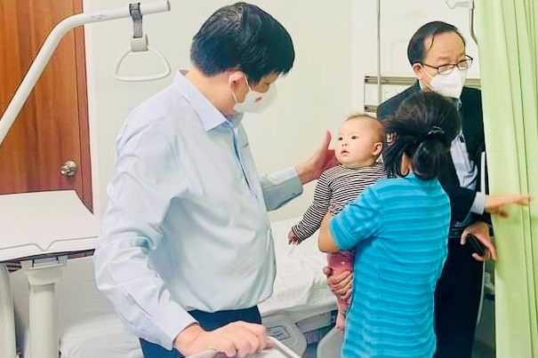Nhấn để xem ảnh chất lượng hơn Bộ trưởng Y tế Nguyễn Thanh Long hỏi thăm sức khỏe của một cháu bé bị tiêm nhầm
